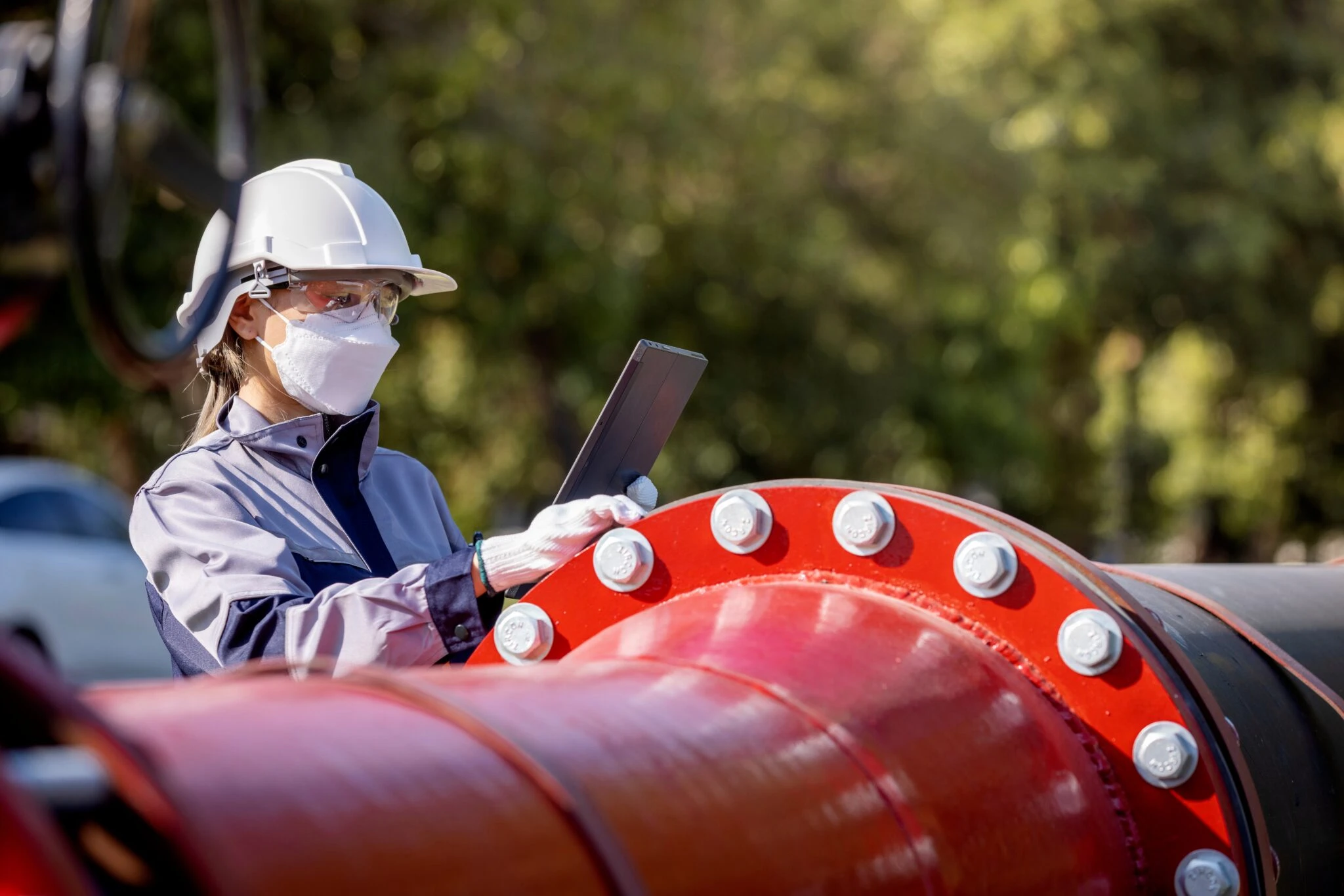 Arbeiter mit Tablet an einer Pipeline